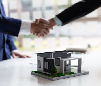 businessman-and-real-estate-agent-shaking-hands-af-2026-01-09-00-56-51-utc Businessman and real estate agent shaking hands after negotiating home purchase agreement.