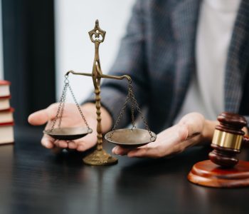 Male lawyer in the office with brass scale on wooden table. just Male lawyer in the modern office with brass scale on wooden table. justice and law concept in morning light